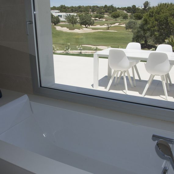 View from inside the bathroom of Casa Madroño looking out on the terrace and the golf course in the background